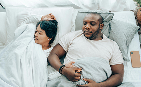 Man and woman asleep in bed